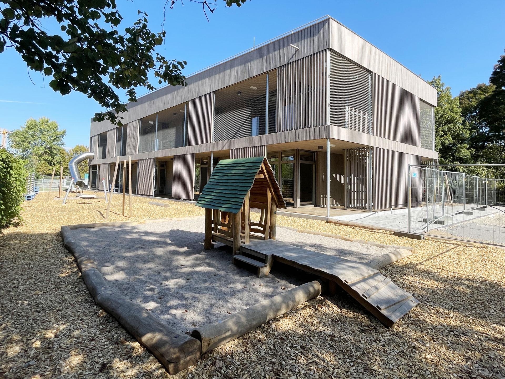 Außenansicht fertiger Kindergarten Weinbrennerplatz mit Spielplatz